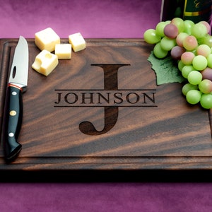 Handmade from natural hardwood personalized cutting board. Never stained, 100% food safe, only finished with food grade mineral oil and beeswax. 12x9 inches Walnut Wooden board with central design number 201 with initial and last name.