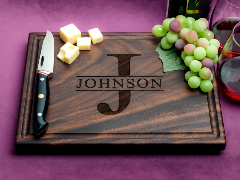 Handmade from natural hardwood personalized cutting board. Never stained, 100% food safe, only finished with food grade mineral oil and beeswax. 12x9 inches Walnut Wooden board with central design number 201 with initial and last name.