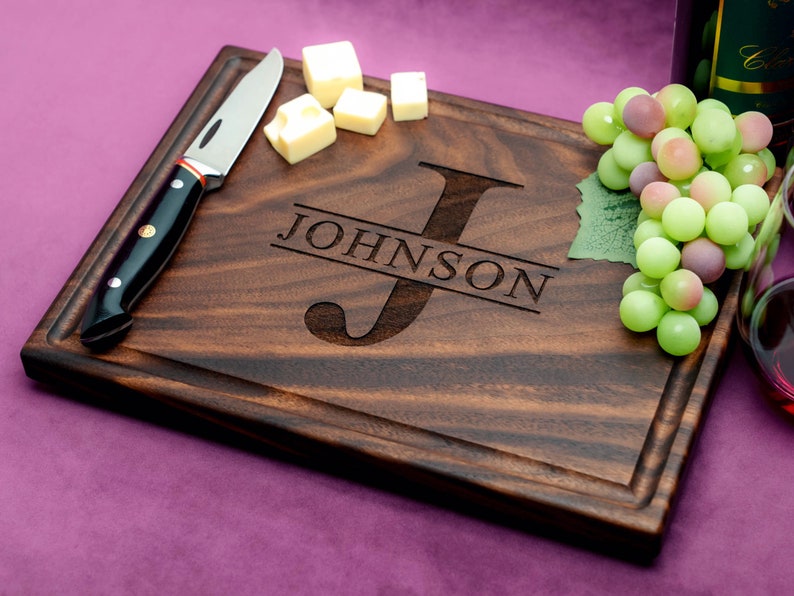 Handmade from natural hardwood personalized cutting board. Never stained, 100% food safe, only finished with food grade mineral oil and beeswax. 12x9 inches Walnut Wooden board with central design number 201 with initial and last name.