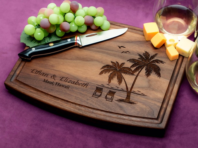 Handmade from natural hardwood personalized cutting board. Never stained, 100% food safe, only finished with food grade mineral oil and beeswax. 12x9 inches Walnut Arched Wooden board with palm trees and beach chairs design number 409.