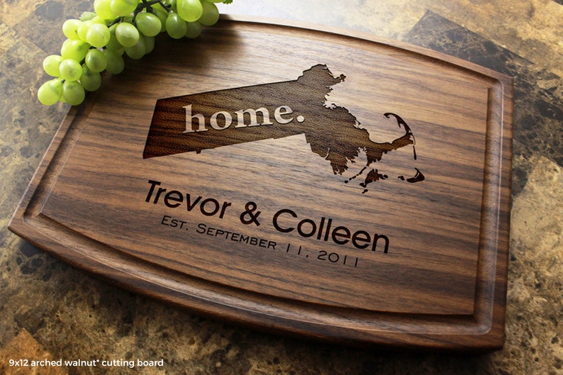 Handmade from natural hardwood personalized cutting board. Never stained, 100% food safe, only finished with food grade mineral oil and beeswax. 12x9 inches Walnut Arched board with central design number 602 with US state, first names, and date.