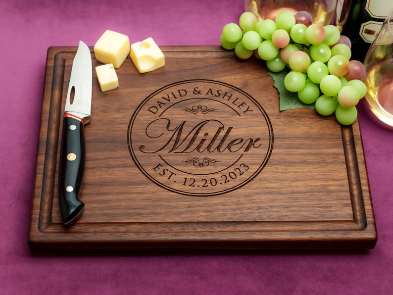 Handmade from natural hardwood personalized cutting board. Never stained, 100% food safe, only finished with food grade mineral oil and beeswax. 12x9 inches Walnut Wooden board with central design number 001 with first names, last name, and date.