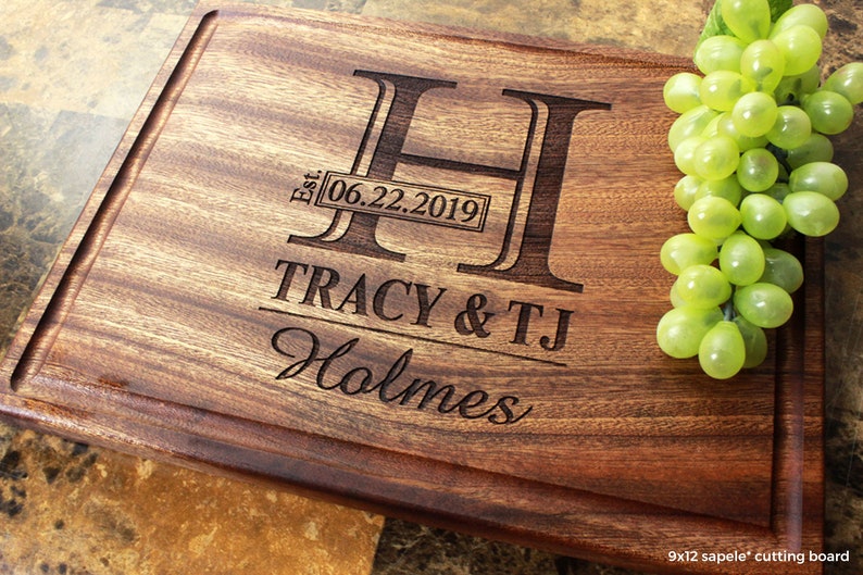 Handmade from natural hardwood personalized cutting board. Never stained, 100% food safe, only finished with food grade mineral oil and beeswax. 12x9 inches Mahogany Wood with central design number 003 with initial, date, first names, and last name.