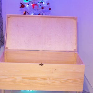 Pu&ograve; includere: Una scatola di legno naturale con un coperchio incernierato. Il coperchio &egrave; aperto e la scatola &egrave; vuota.
