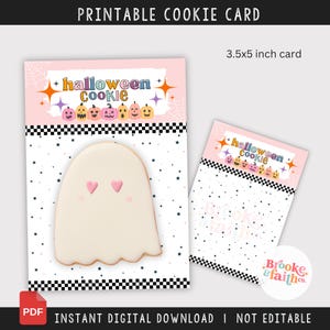 Może przedstawiać: Drukowana karta do ciasteczek na Halloween z ciasteczkiem w kształcie ducha. Karta ma wymiary 8,89 cm x 12,7 cm i zawiera tekst "Halloween Cookie" oraz "Natychmiastowe pobieranie cyfrowe". Ciasteczko ma różowe oczy w kształcie serca.