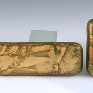 May include: Three square and rectangular green glass tiles with gold leaf accents. The tiles have a textured surface and are perfect for adding a touch of elegance to any space.