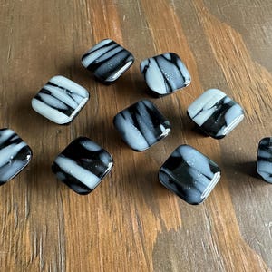 May include: Nine square-shaped glass cabinet knobs with a black and white marbled pattern.