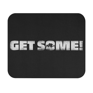 May include: Black mouse pad with white text that reads "GET SOME!" with a stylized spider graphic in the middle of the text.