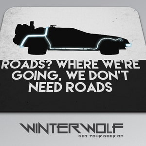 May include: A rectangular mousepad featuring a black silhouette of a DeLorean time machine with blue neon accents. The text "ROADS? WHERE WE'RE GOING, WE DON'T NEED ROADS" is displayed in white. The Winterwolf logo is at the bottom.