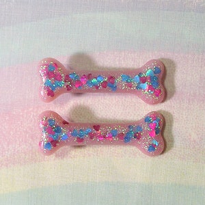 May include: Two pink bone-shaped charms with blue and pink glitter hearts.