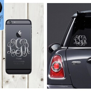 Może przedstawiać: Czarny iPhone ze srebrną naklejką z monogramem z literami LGR. Telefon leży na jasnej drewnianej powierzchni. Na zdjęciu widoczny jest również samochód z pasującą naklejką z monogramem.
