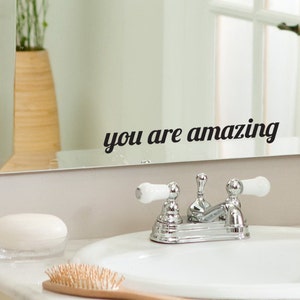 May include: A bathroom mirror with a black vinyl decal that reads "you are amazing".