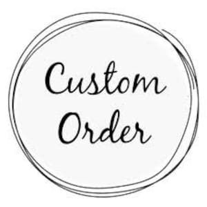 May include: A white circle with a black outline and the text "Custom Order" in black cursive writing.