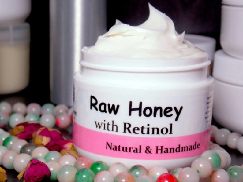 May include: A white jar of Raw Honey with Retinol face cream. The jar has a pink label with black text that reads "Raw Honey with Retinol Natural & Handmade".