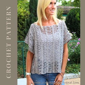 Könnte beinhalten: Ein hellgraues Häkeltop mit kurzen Ärmeln und einem quadratischen Ausschnitt. Das Top hat ein offenes, strukturiertes Design. Die Worte "CROCHET PATTERN" sind vertikal auf der linken Seite des Bildes aufgedruckt. Das Model trägt eine blaue Jeans.