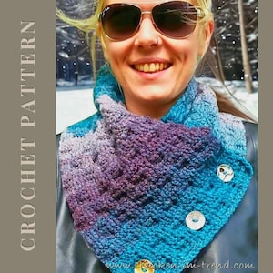 Könnte beinhalten: Ein handgehäkelter Schal in Blau-, Lila- und Türkistönen, befestigt mit zwei großen Zierknöpfen. Der Text "CROCHET PATTERN" ist links sichtbar. Ein modisches Accessoire.