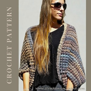 Könnte beinhalten: Ein mehrfarbiger, offener Häkelschal mit einem strukturierten Stichmuster. Der Schal hat Brauntöne, Blau und Beige. Die Worte "CROCHET PATTERN" sind vertikal auf der linken Seite des Bildes aufgedruckt. Die Website "www.stricken-im-trend.com" ist unten aufgedruckt.