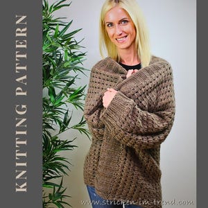 May include: A woman wearing a brown knitted cardigan with a textured pattern. The cardigan is wrapped around the person. The words "KNITTING PATTERN" are printed vertically on the left side of the image.