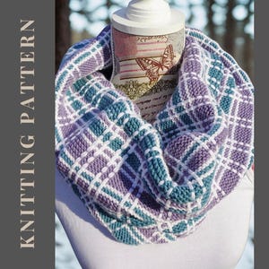 May include: A knitted infinity scarf in shades of purple, teal, and white, displayed on a mannequin. The scarf features a plaid pattern. The words "KNITTING PATTERN" are printed on the left side of the image.
