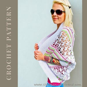 Könnte beinhalten: Ein weißer Häkelschal mit Lochärmeln und rosa und grünen Streifen. Der Text "CROCHET PATTERN" befindet sich auf der linken Seite. Die Website www.stricken-im-trend.com befindet sich unten im Bild.