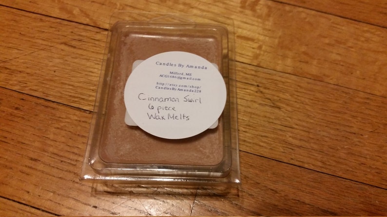 Peut inclure: Un r&eacute;cipient en plastique transparent contenant une fonte de cire brune. L'&eacute;tiquette indique "Candles By Amanda", "Milford, MI", "CandlesByAmanda.com", "http://etsy.com/shop/CandlesByAmanda229", "Cinnamon Swirl", "6 piece", "Wax Melts".