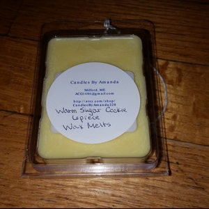 Peut inclure: Une &eacute;tiquette ronde blanche avec du texte noir indique "Candles By Amanda", "Maford, ME", "ACG16@gmail.com", "http://etsy.com/shop/CandlesByAmanda224", "Warm Sugar Cookie Lepiece Wax Melts". L'&eacute;tiquette est fix&eacute;e &agrave; un r&eacute;cipient en plastique transparent contenant une fonte de cire jaune.