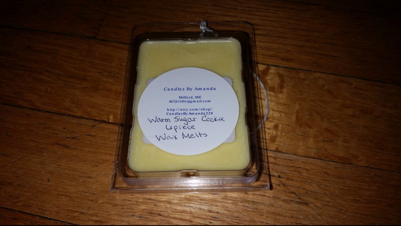 Peut inclure: Une &eacute;tiquette ronde blanche avec du texte noir indique "Candles By Amanda", "Maford, ME", "ACG16@gmail.com", "http://etsy.com/shop/CandlesByAmanda224", "Warm Sugar Cookie Lepiece Wax Melts". L'&eacute;tiquette est fix&eacute;e &agrave; un r&eacute;cipient en plastique transparent contenant une fonte de cire jaune.