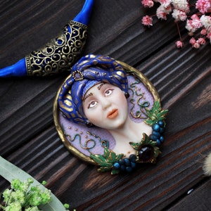 Woman with grapes, designer jewelry decorated of gemstones, exclusive necklace with vineyards