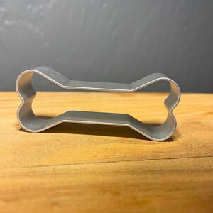Bake adorable dog bone-shaped treats with this stainless steel cookie cutter! Great for homemade pet treats, themed parties, and fun baking projects. Durable, reusable, and easy to clean!