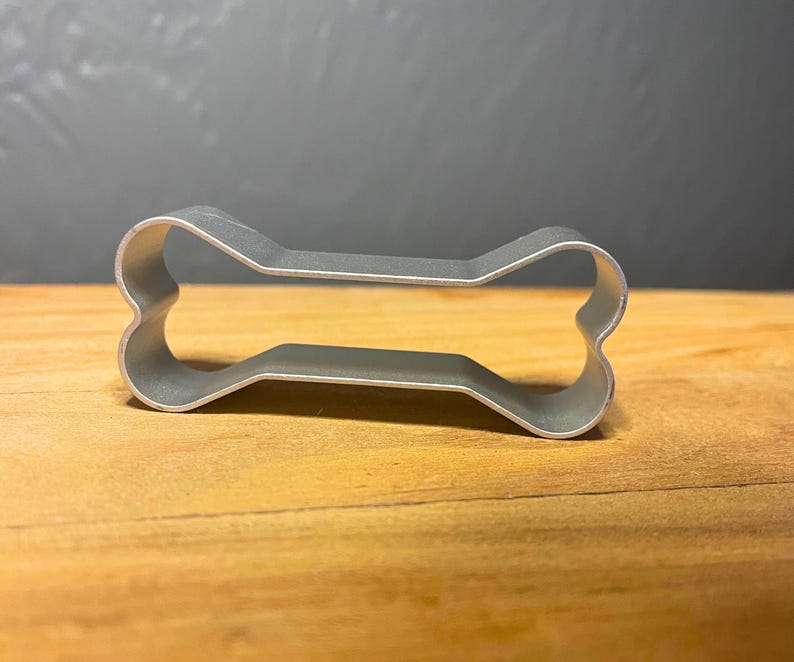 Bake adorable dog bone-shaped treats with this stainless steel cookie cutter! Great for homemade pet treats, themed parties, and fun baking projects. Durable, reusable, and easy to clean!