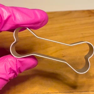 Looking for a fun way to create pet-friendly treats? This bone-shaped cookie cutter is ideal for crafting dog biscuits, fondant decorations, and playful themed cookies. Made from sturdy stainless steel, it provides clean cuts and easy dough release. Whether you're baking for your furry friend or making dog-themed party treats, this versatile cutter will help bring your creations to life. A perfect addition to any pet lover’s kitchen!