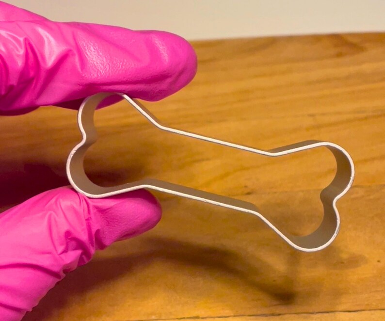 Looking for a fun way to create pet-friendly treats? This bone-shaped cookie cutter is ideal for crafting dog biscuits, fondant decorations, and playful themed cookies. Made from sturdy stainless steel, it provides clean cuts and easy dough release. Whether you're baking for your furry friend or making dog-themed party treats, this versatile cutter will help bring your creations to life. A perfect addition to any pet lover’s kitchen!