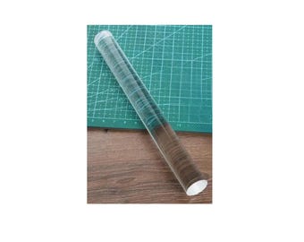 Könnte beinhalten: Ein transparenter Acryl-Nudelholz mit Messmarkierungen auf einer grünen Schneidematte.