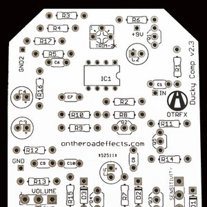 May include: A white printed circuit board with electronic components, including resistors, capacitors, diodes, and an integrated circuit. The board is labeled "Ducky Comp v2.3" and "ontheroadeffects.com".