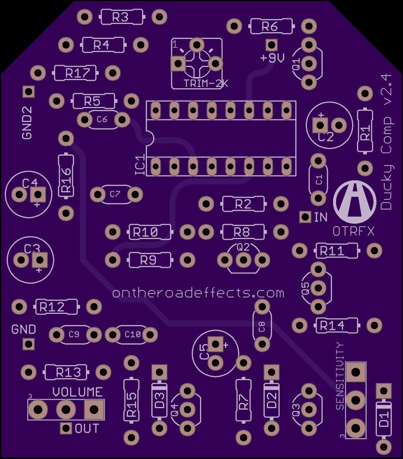 May include: A purple printed circuit board for the Ducky Comp v2.4 guitar pedal. The board features labelled component placements including resistors R1 through R17, capacitors C1 through C10, transistors Q1 through Q5, and an IC1 socket. Text includes OTRFX.