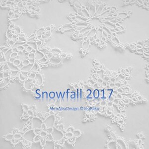May include: White lace snowflakes on a white background. The text "Snowfall 2017" is written in blue text below the snowflakes. The text "AlanAleaDesign, ©LeaRako" is written in blue text below the "Snowfall 2017" text.