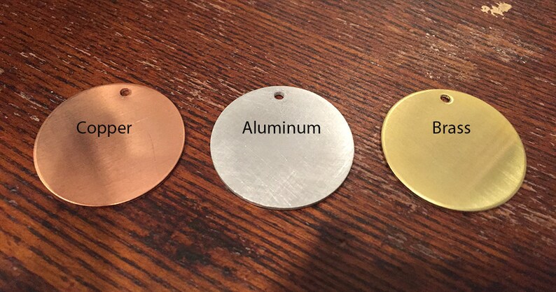 May include: Three round metal discs, each with a different finish: copper, aluminum, and brass. The discs have a hole in the center.