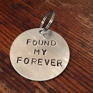 May include: Silver keychain with a round tag that says "FOUND MY FOREVER".