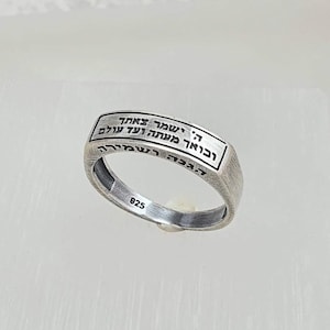 Peut inclure: Une bague en argent avec une inscription en hébreu. L'inscription se lit comme suit : "L'Éternel est mon berger, je ne manquerai de rien". La bague est estampillée "925" à l'intérieur.