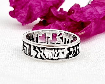May include: A silver ring with Hebrew lettering engraved around the band.