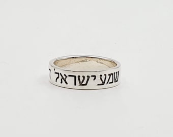 May include: A silver ring with the Hebrew words "Shema Yisrael" engraved on the band.