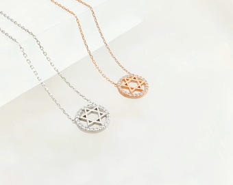 May include: Two silver necklaces with a Star of David pendant. The pendant is a circle with a Star of David inside and small clear stones around the edge.