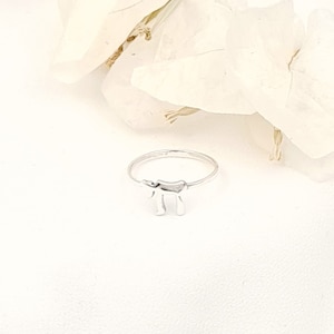 May include: A silver ring with a Hebrew letter 'Chai' charm. The ring is on a white background.