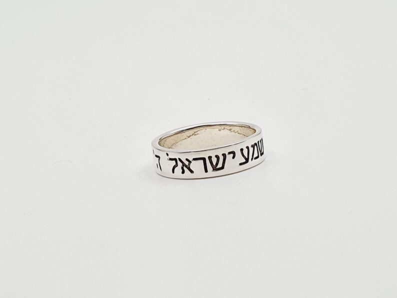 Puede incluir: Un anillo de plata con las palabras hebreas "עשה לך" grabadas en la banda.