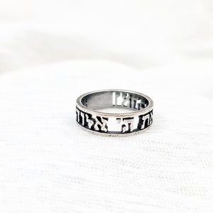 May include: A silver ring with Hebrew lettering engraved around the band.