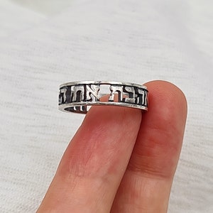 May include: A silver ring with Hebrew lettering around the band.