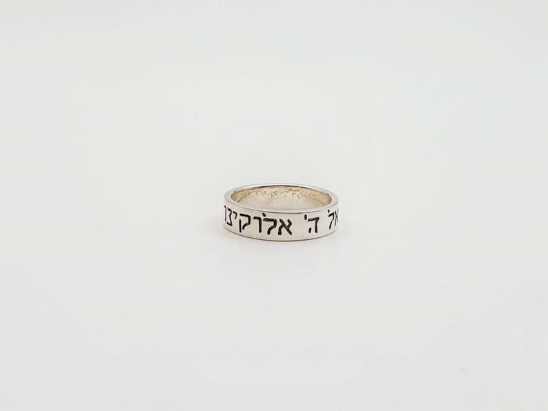 Puede incluir: Un anillo de plata con las palabras hebreas "אהיה אלקיך" grabadas en la banda.