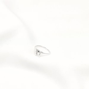 May include: A silver ring with a simple design featuring the Hebrew letter "Chai" which means "life".
