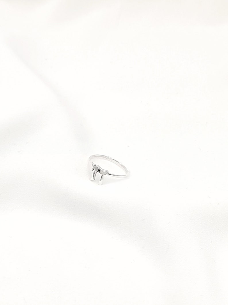 May include: A silver ring with a simple design featuring the Hebrew letter "Chai" which means "life".