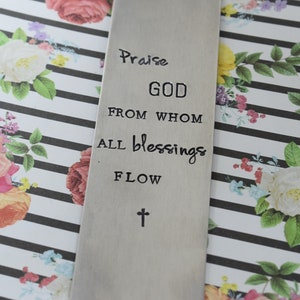 May include: Silver bookmark with the text "Praise GOD from whom all blessings flow" and a cross at the bottom.